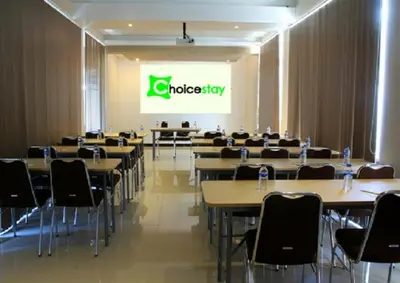 a conference room with tables and chairs and a sign at Choice Stay Hotel Denpasar in Denpasar