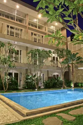 a hotel with a swimming pool in front of a building at Choice Stay Hotel Denpasar in Denpasar