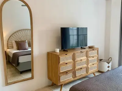 a bedroom with a dresser with a tv and a mirror at Heart of Seminyak 2bed 2bath 2 pools super quiet in Seminyak