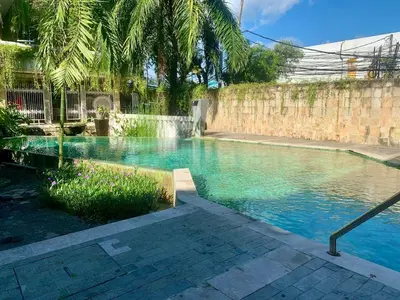 a swimming pool with blue water next to a wall at Heart of Seminyak 2bed 2bath 2 pools super quiet in Seminyak