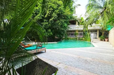 a swimming pool with a bench in front of a building at Heart of Seminyak 2bed 2bath 2 pools super quiet in Seminyak