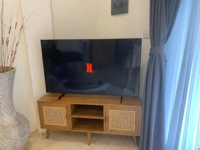 a flat screen tv sitting on top of a wooden entertainment center at Heart of Seminyak 2bed 2bath 2 pools super quiet in Seminyak