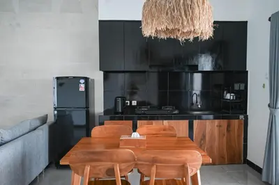 a kitchen with a wooden table and chairs at Villa Taman Sari in Nusa Dua