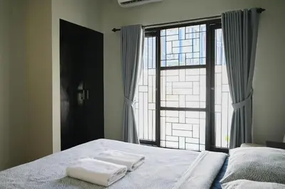 two towels on a bed in front of a window at Villa Taman Sari in Nusa Dua