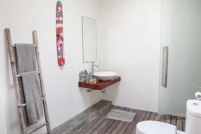 a white bathroom with a sink and a mirror at Villa Turtle in Seminyak