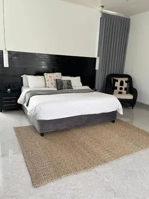 a bedroom with a large bed and a chair at Deo Villa Seminyak in Seminyak