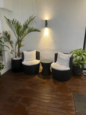 two chairs and a table in a room with plants at Deo Villa Seminyak in Seminyak
