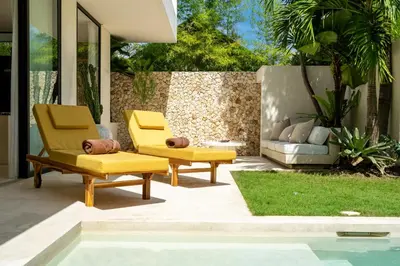 two yellow chairs sitting next to a pool at 2 bedroom villa with large garden and near Canggu in Kerobokan