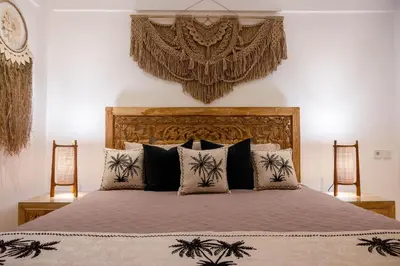 a bedroom with a large bed with black and white pillows at Bali Bliss Jayakarta Apartments in Seminyak