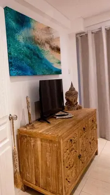 a television on top of a wooden cabinet in a room at Bali Bliss Jayakarta Apartments in Seminyak