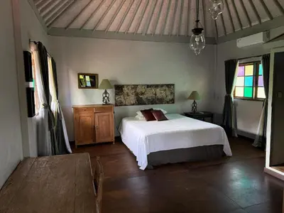 a bedroom with a white bed and some windows at Villa Olita in Canggu