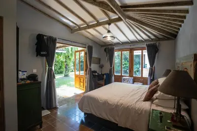 a bedroom with a bed and a door to a yard at Villa Olita in Canggu