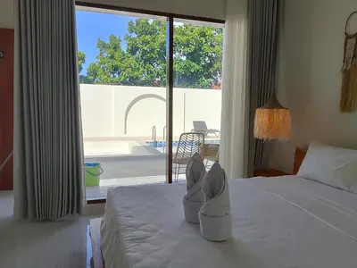 a bedroom with a bed with a pair of shoes on it at Apartemen JIRO BALI in Ngurah Rai International Airport