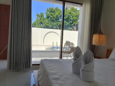 a hotel room with a bed with white shoes on it at Apartemen JIRO BALI in Ngurah Rai International Airport