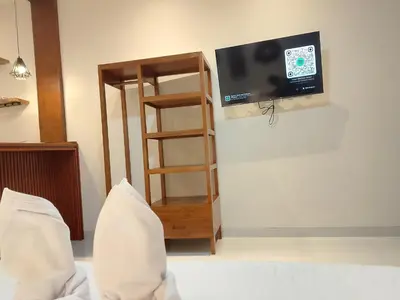 a room with a tv and a book shelf at Apartemen JIRO BALI in Ngurah Rai International Airport