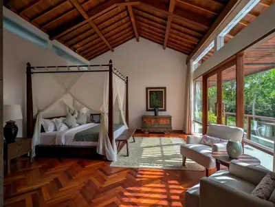 a bedroom with a canopy bed and a living room at Jeeva Tirta Seminyak in Canggu
