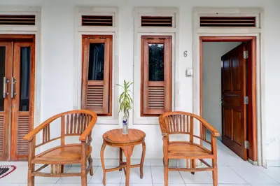 two chairs and a table in front of a house at Collection O Budget Door Legian Inn @Poppies Road in Legian