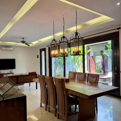 a dining room with a wooden table and chairs at Tolgay Living Villas in Seminyak