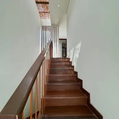 a staircase in a house with wooden floors and white walls at Tolgay Living Villas in Seminyak