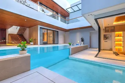 an indoor swimming pool in a house at Villa Brandon by Nakula in Jimbaran