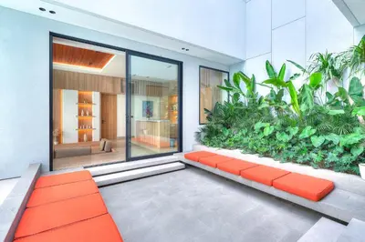 a living room with an orange bench and plants at Villa Brandon by Nakula in Jimbaran