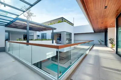a house with glass walls and a swimming pool at Villa Brandon by Nakula in Jimbaran