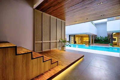 an open living room with a staircase and a swimming pool at Villa Brandon by Nakula in Jimbaran