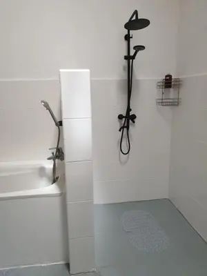 a white bathroom with a shower and a tub at Vina villa in Kerobokan
