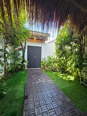 a garden with a walkway in front of a house at Vina villa in Kerobokan