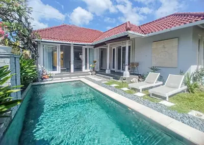 a villa with a swimming pool in front of a house at villa Bunga in Seminyak