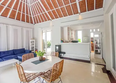 a living room with a blue couch and a table and chairs at villa Bunga in Seminyak
