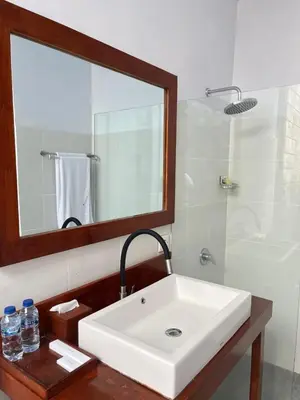 a bathroom with a white sink and a mirror at villa Bunga in Seminyak