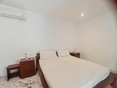 a bedroom with a white bed and two night stands at villa Bunga in Seminyak