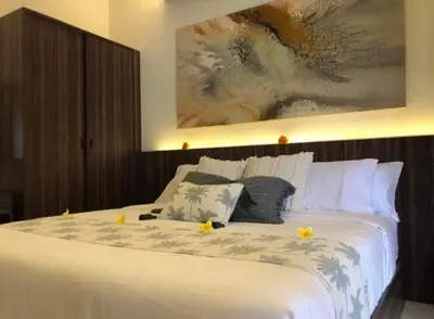 a bedroom with a large white bed with flowers on it at Villa Sooni 1 in Seminyak