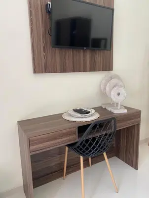 a desk with a chair and a television on a wall at Villa Sooni 1 in Seminyak