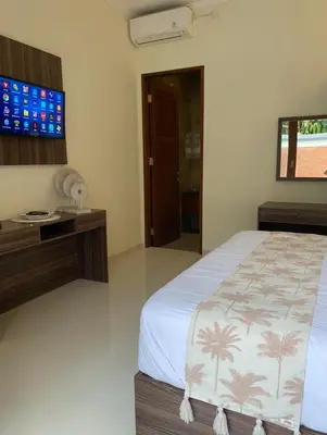 a bedroom with a bed and a flat screen tv at Villa Sooni 1 in Seminyak