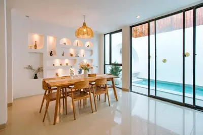 a dining room with a wooden table and chairs at Casa Yo-Na Seminyak in Seminyak