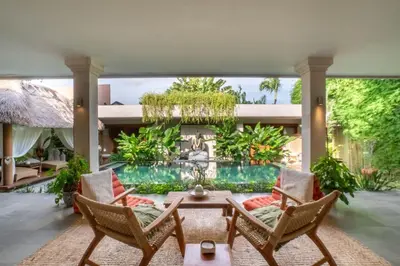 a living room with a pool and chairs and a table at Spacious Charming 4BR Balinese Villa, Seminyak in Kerobokan