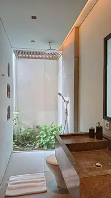 a bathroom with a toilet and a glass shower at Hanupis Canggu Apartment in Canggu