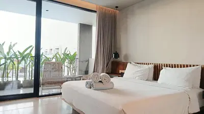 a hotel room with two beds and a large window at Hanupis Canggu Apartment in Canggu
