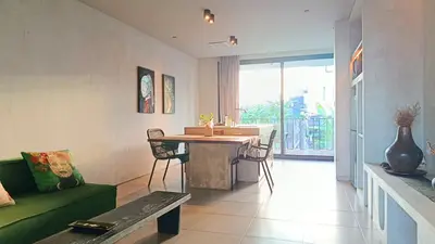 a living room with a green couch and a table at Hanupis Canggu Apartment in Canggu