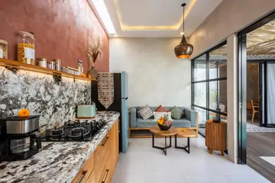 a kitchen with a stove and a living room at Modern and Petite 2bd Seminyak Villa Construction Near in Seminyak