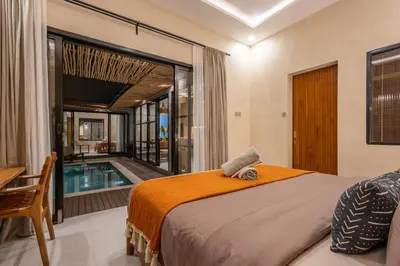 a bedroom with a bed and a swimming pool at Modern and Petite 2bd Seminyak Villa Construction Near in Seminyak
