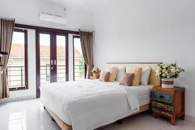 a white bedroom with a large bed and a window at Unique Villa Jimbaran in Jimbaran