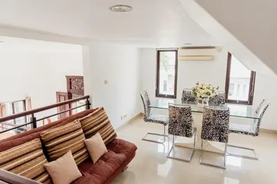 a living room with a couch and a table and chairs at Unique Villa Jimbaran in Jimbaran