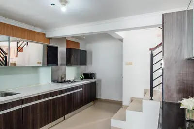 a kitchen with wooden cabinets and a staircase in it at Unique Villa Jimbaran in Jimbaran