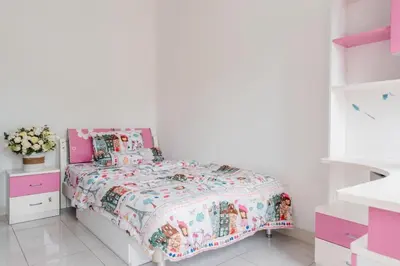 a white bedroom with a bed with a floral bedspread at Unique Villa Jimbaran in Jimbaran