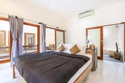a bedroom with a large bed and a bath tub at Villa Durna 2 in Seminyak