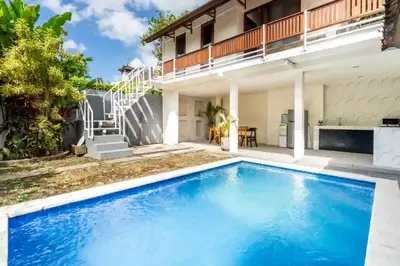 a swimming pool in front of a house at Villa Durna 2 in Seminyak