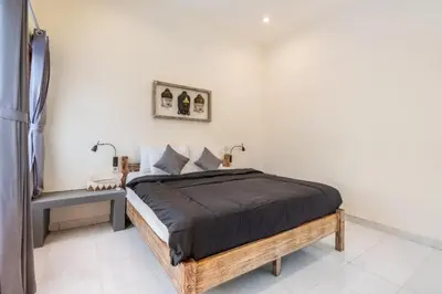 a bedroom with a bed with a wooden frame at Villa Durna 2 in Seminyak